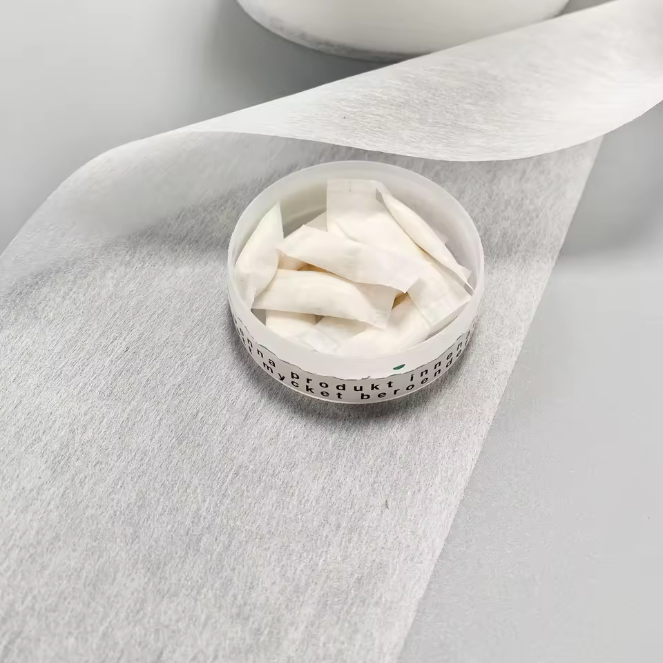 Pouch-grade snus paper material with finished oral pouches