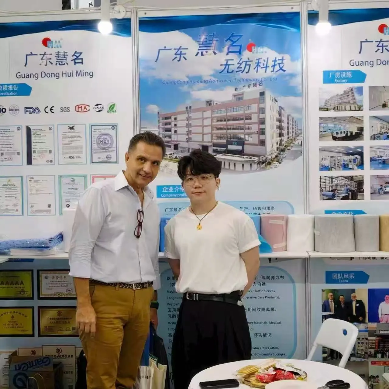 Photo with visitor at exhibition booth displaying Huiming materials